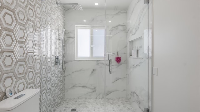 bathroom with toilet and a marble finish shower