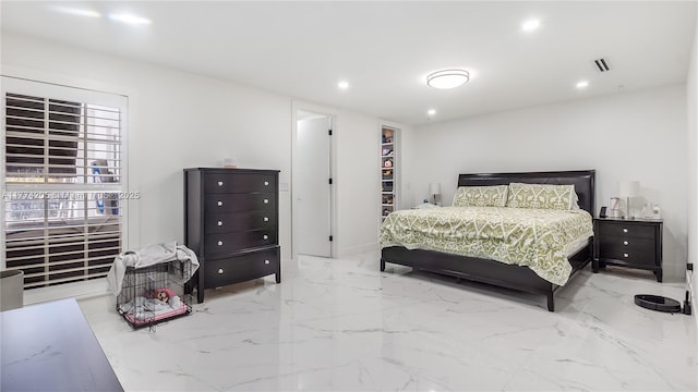 bedroom featuring marble tiled flooring, recessed lighting, and a walk in closet