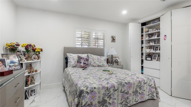 bedroom featuring light marble finish flooring and recessed lighting
