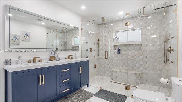 bathroom featuring toilet, a stall shower, and double vanity