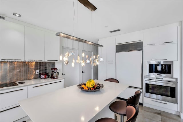 15811 Collins Ave Unit 2506, Sunny Isles Beach, FL 33160 - kitchen with built in fridge, modern cabinets, a breakfast bar, and decorative backsplash