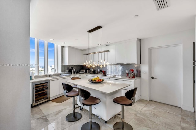 15811 Collins Ave Unit 2506, Sunny Isles Beach, FL 33160 - kitchen featuring beverage cooler, a sink, decorative backsplash, and light countertops