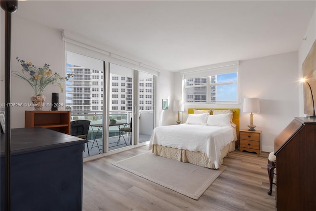 bedroom featuring access to exterior and light wood-type flooring