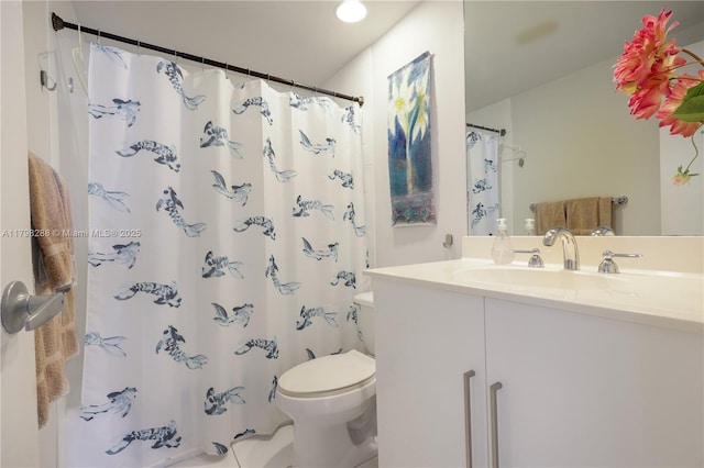 bathroom featuring toilet, vanity, and a shower with curtain