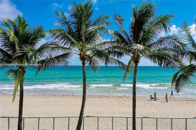 water view featuring local beach and fence