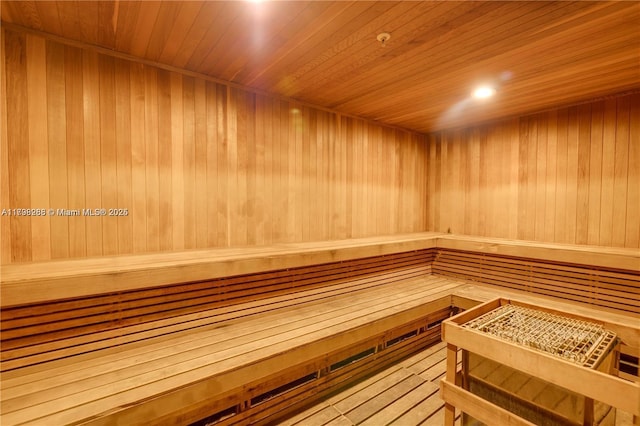 relaxing sauna / steam room with wooden ceiling, wooden walls, and recessed lighting