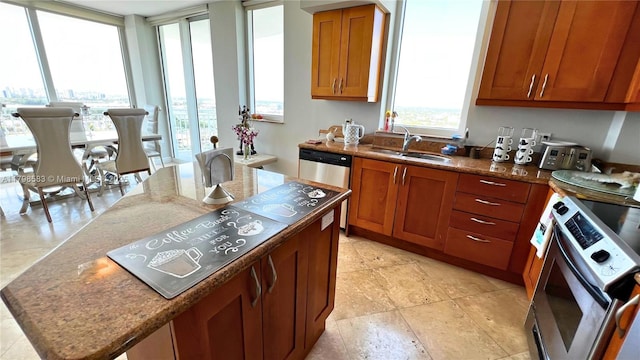 1745 E Hallandale Beach Blvd Unit 2007W, Hallandale Beach, FL 33009 - kitchen featuring a sink, a kitchen island, brown cabinetry, appliances with stainless steel finishes, and dark stone counters