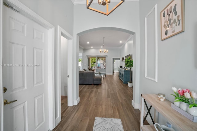 1199 NW 166th Ave, Pembroke Pines, FL 33028 - hallway with arched walkways, a chandelier, ornamental molding, dark wood finished floors, and baseboards
