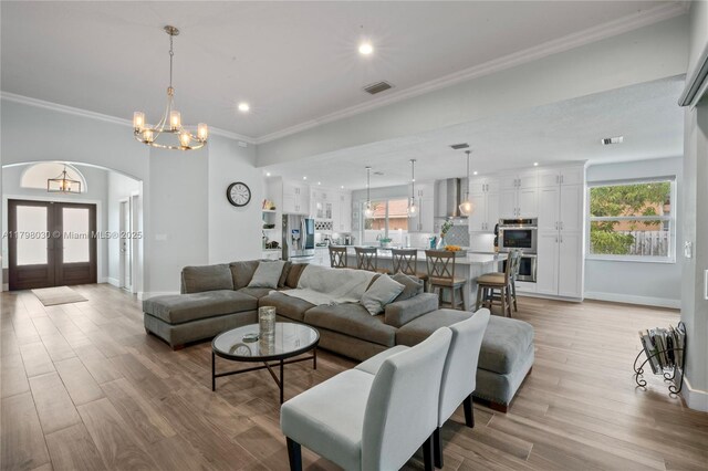 1199 NW 166th Ave, Pembroke Pines, FL 33028 - living area featuring arched walkways, baseboards, light wood finished floors, crown molding, and a chandelier