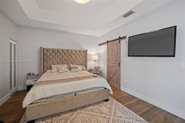 1199 NW 166th Ave, Pembroke Pines, FL 33028 - bedroom with a raised ceiling, a barn door, baseboards, and wood finished floors