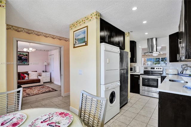 1450 NW 18th Ave Unit 203, Delray Beach, FL 33445 - kitchen with stainless steel appliances, wall chimney exhaust hood, estacked washer and dryer, dark cabinets, and a sink