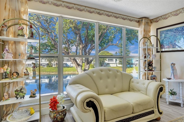 1450 NW 18th Ave Unit 203, Delray Beach, FL 33445 - living area with a water view, a textured ceiling, healthy amount of natural light, and wood finished floors