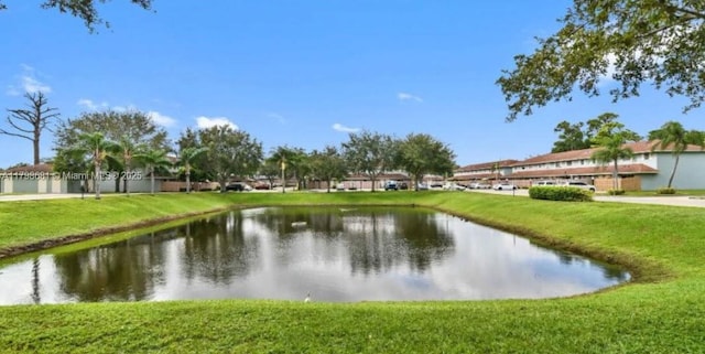 surrounding community featuring a water view and a lawn