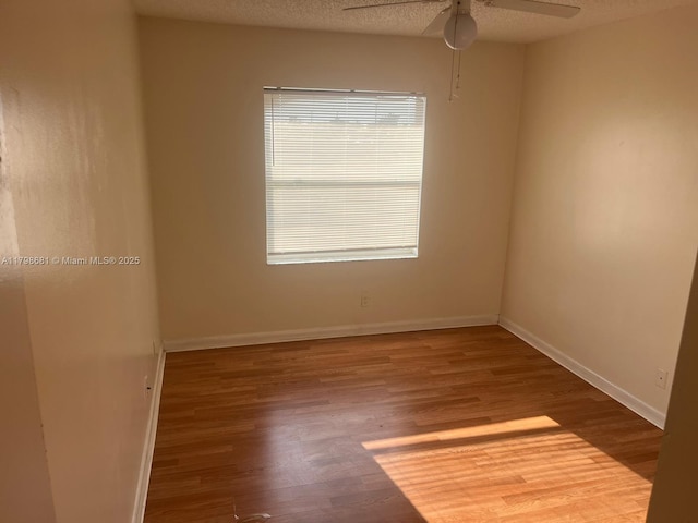 unfurnished room featuring wood finished floors, ceiling fan, and baseboards