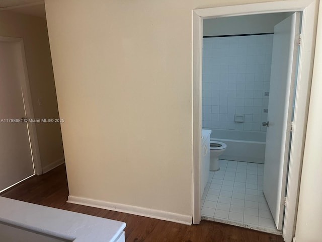 hallway with wood finished floors and baseboards
