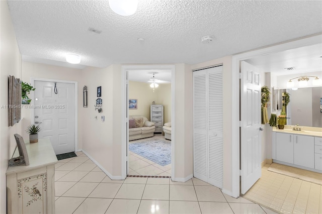 2541 N Nob Hill Rd Unit 205, Sunrise, FL 33322 - corridor with a textured ceiling, light tile patterned floors, a sink, and baseboards
