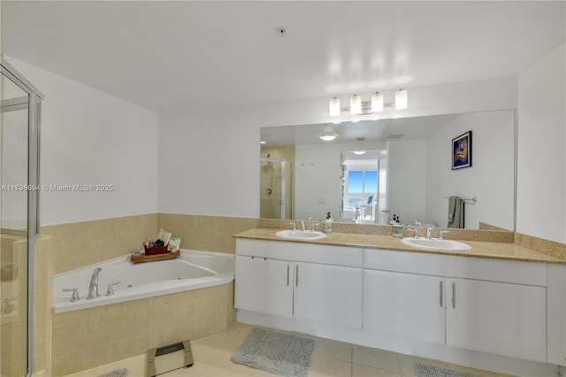 full bathroom featuring a shower stall, a garden tub, double vanity, and tile patterned flooring