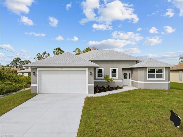 prairie-style home featuring stucco siding, an attached garage, a front yard, driveway, and a shingled roof