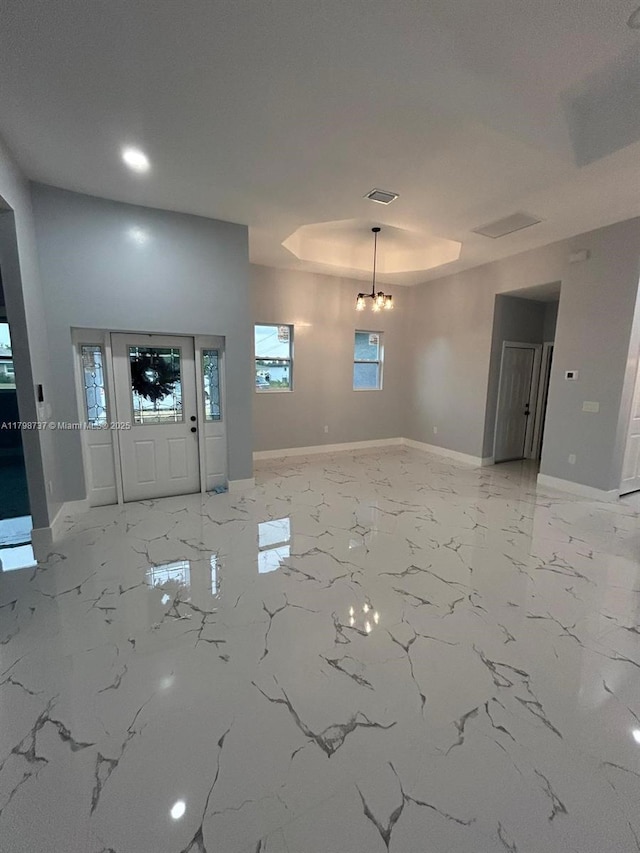 entrance foyer featuring baseboards, light marble finish flooring, a tray ceiling, and recessed lighting