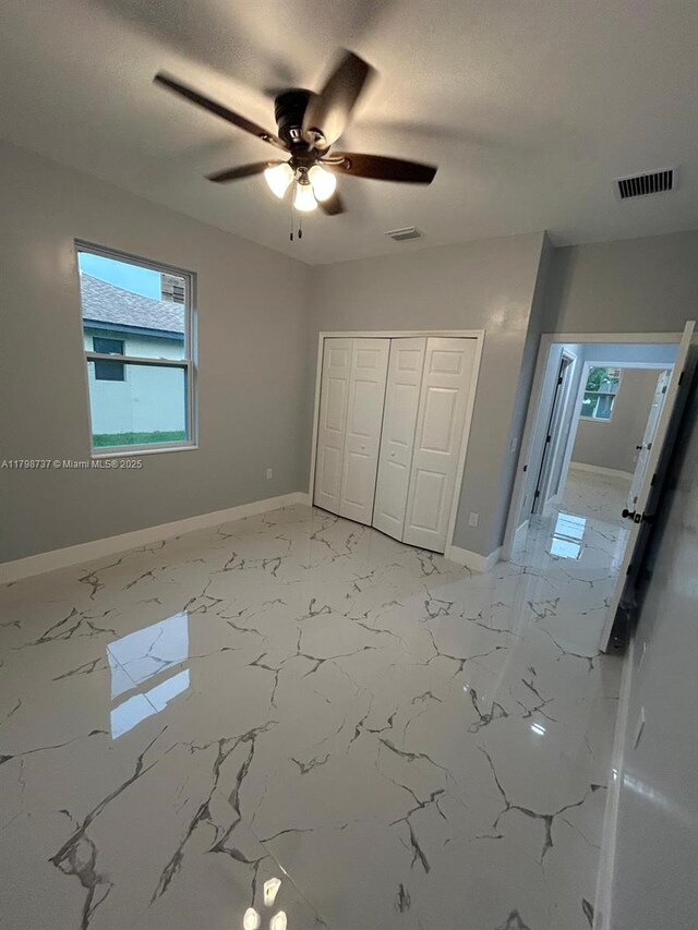 unfurnished bedroom with baseboards, a closet, and ceiling fan