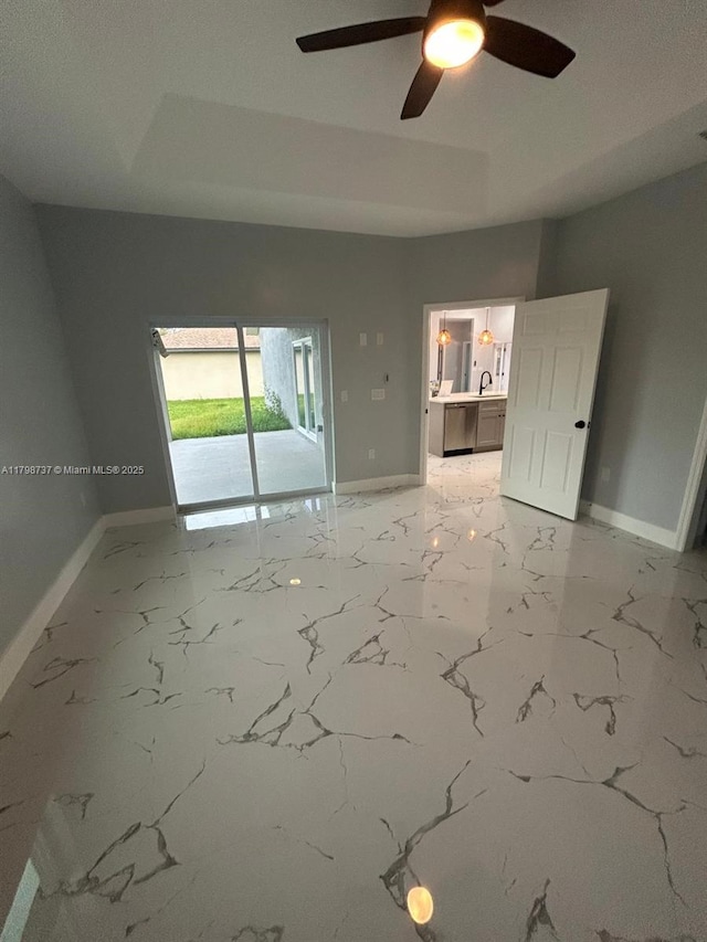 spare room with baseboards, ceiling fan, and light marble finish flooring