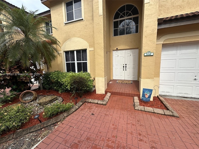 238 Magnolia Ave, Davie, FL 33325 - view of exterior entry with stucco siding and a garage