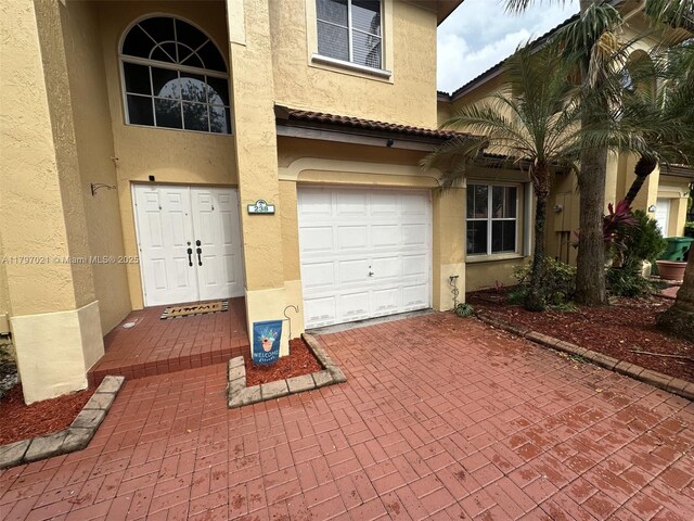 238 Magnolia Ave, Davie, FL 33325 - entrance to property featuring stucco siding, a garage, and decorative driveway