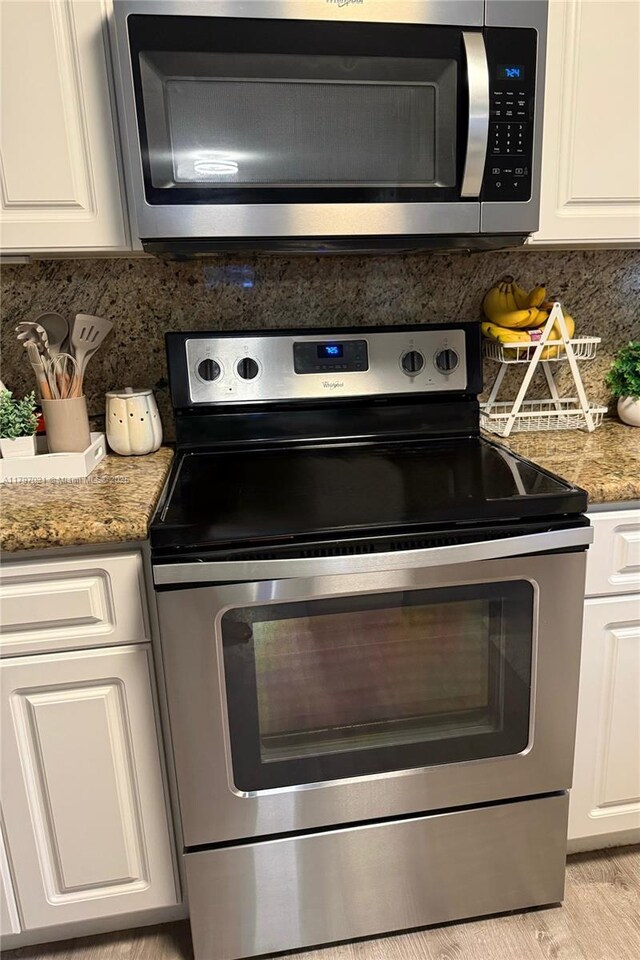 238 Magnolia Ave, Davie, FL 33325 - kitchen view of stainless steel appliances, backsplash, and white cabinetry