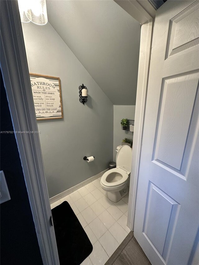 238 Magnolia Ave, Davie, FL 33325 - bathroom with lofted ceiling, tile patterned flooring, toilet, and baseboards