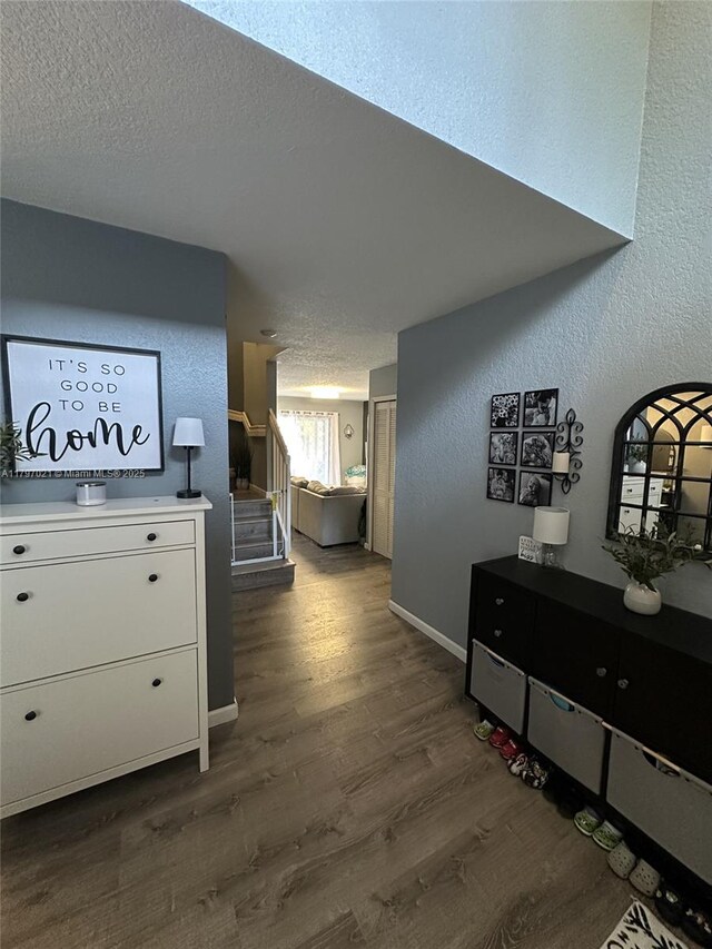 238 Magnolia Ave, Davie, FL 33325 - hall featuring dark wood finished floors, a textured ceiling, stairway, baseboards, and a textured wall