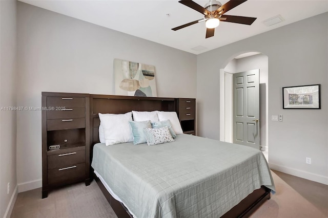 bedroom with baseboards, arched walkways, a ceiling fan, and light colored carpet