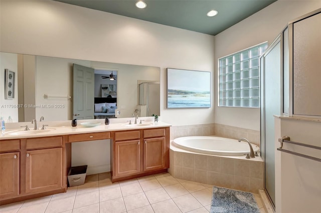 full bath featuring tile patterned floors, a shower stall, double vanity, a bath, and recessed lighting