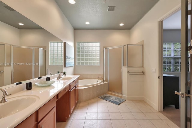 full bathroom with a bath, a shower stall, double vanity, and recessed lighting