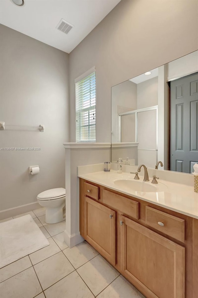 full bath featuring a shower stall, tile patterned flooring, vanity, toilet, and baseboards