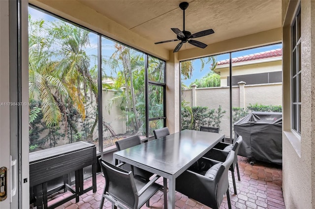 sunroom / solarium featuring ceiling fan and outdoor dining area