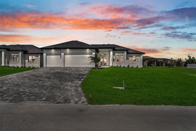 1212 NW 35th Pl, Cape Coral, FL 33993 - prairie-style home featuring an attached garage, driveway, a lawn, and stucco siding