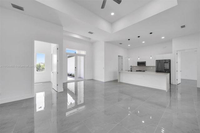 1212 NW 35th Pl, Cape Coral, FL 33993 - unfurnished living room with baseboards, a high ceiling, recessed lighting, ceiling fan, and a sink