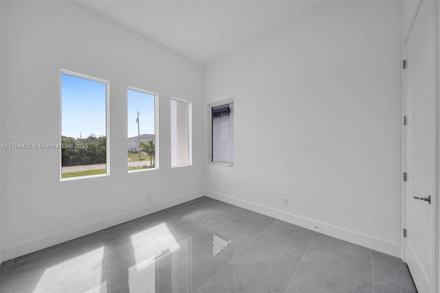 1212 NW 35th Pl, Cape Coral, FL 33993 - spare room featuring baseboards and marble look tile flooring