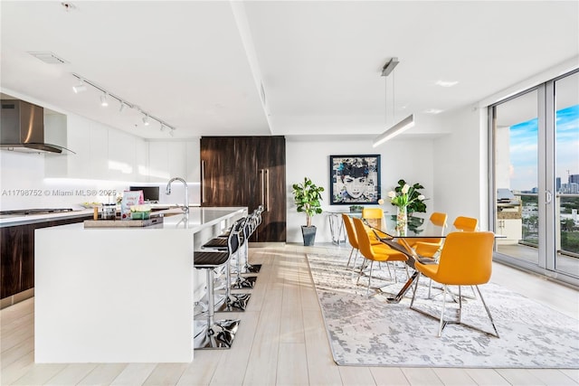 1180 N Federal Hwy Unit 1407, Fort Lauderdale, FL 33304 - kitchen with wall chimney exhaust hood, modern cabinets, track lighting, light countertops, and a wall of windows