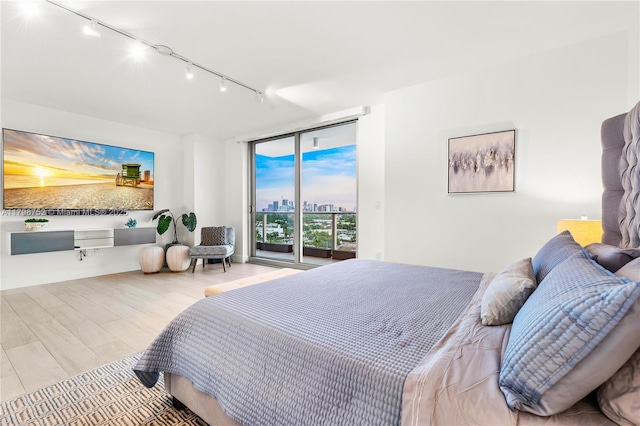 1180 N Federal Hwy Unit 1407, Fort Lauderdale, FL 33304 - bedroom featuring track lighting, access to exterior, wood finished floors, and a wall of windows