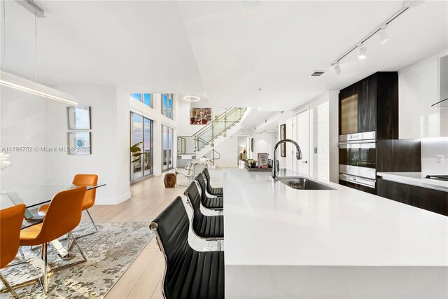 1180 N Federal Hwy Unit 1407, Fort Lauderdale, FL 33304 - kitchen featuring a sink, modern cabinets, oven, rail lighting, and light wood-style flooring