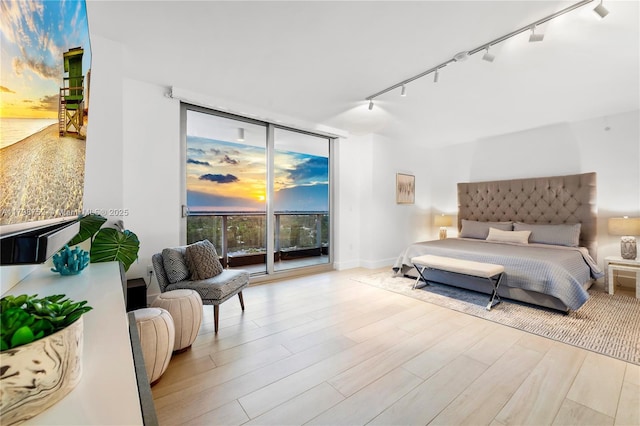 1180 N Federal Hwy Unit 1407, Fort Lauderdale, FL 33304 - bedroom featuring a wall of windows, access to exterior, track lighting, and wood finished floors