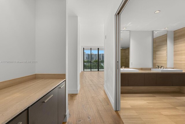 bathroom with double vanity, wood finished floors, and recessed lighting