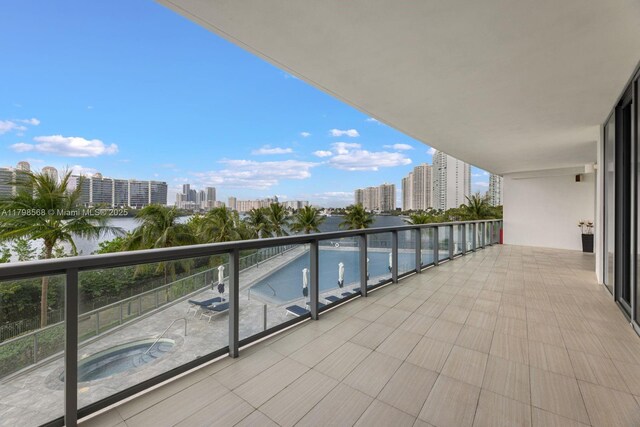 balcony with a view of city and an in-ground hot tub