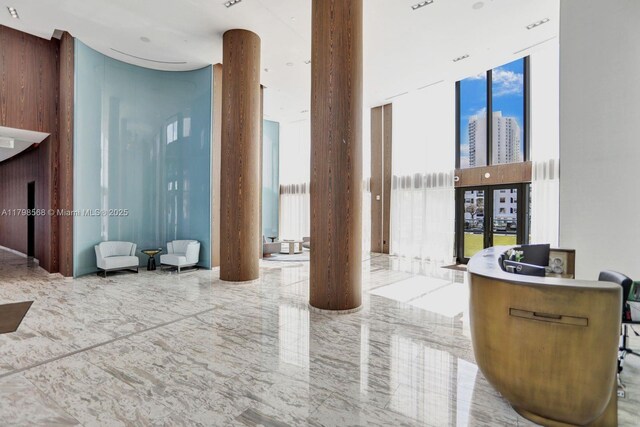 common area featuring a wall of windows, a high ceiling, and a view of city