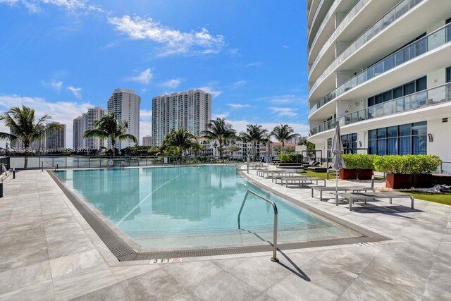 community pool with a patio and a view of city