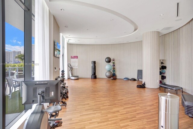 workout area with light wood finished floors and wallpapered walls