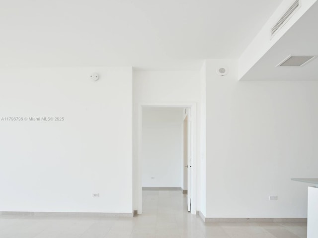 spare room featuring baseboards and a smoke detector