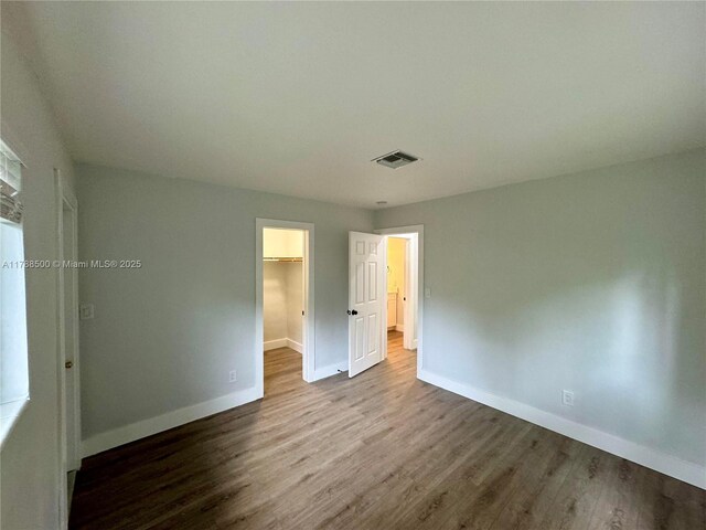 2641 SW 13th Ave, Fort Lauderdale, FL 33315 - unfurnished bedroom with baseboards, a spacious closet, wood finished floors, and a closet