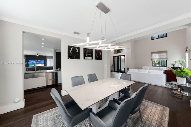 dining area with dark wood finished floors, ornamental molding, and baseboards